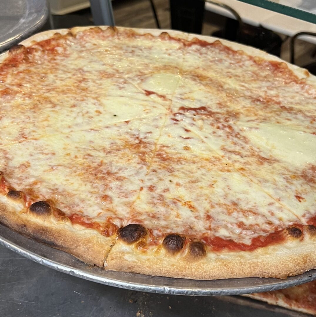 A pizza sitting on top of a pan covered in cheese.