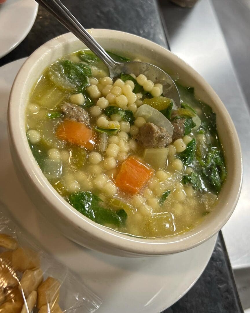 A bowl of soup with meat and vegetables.