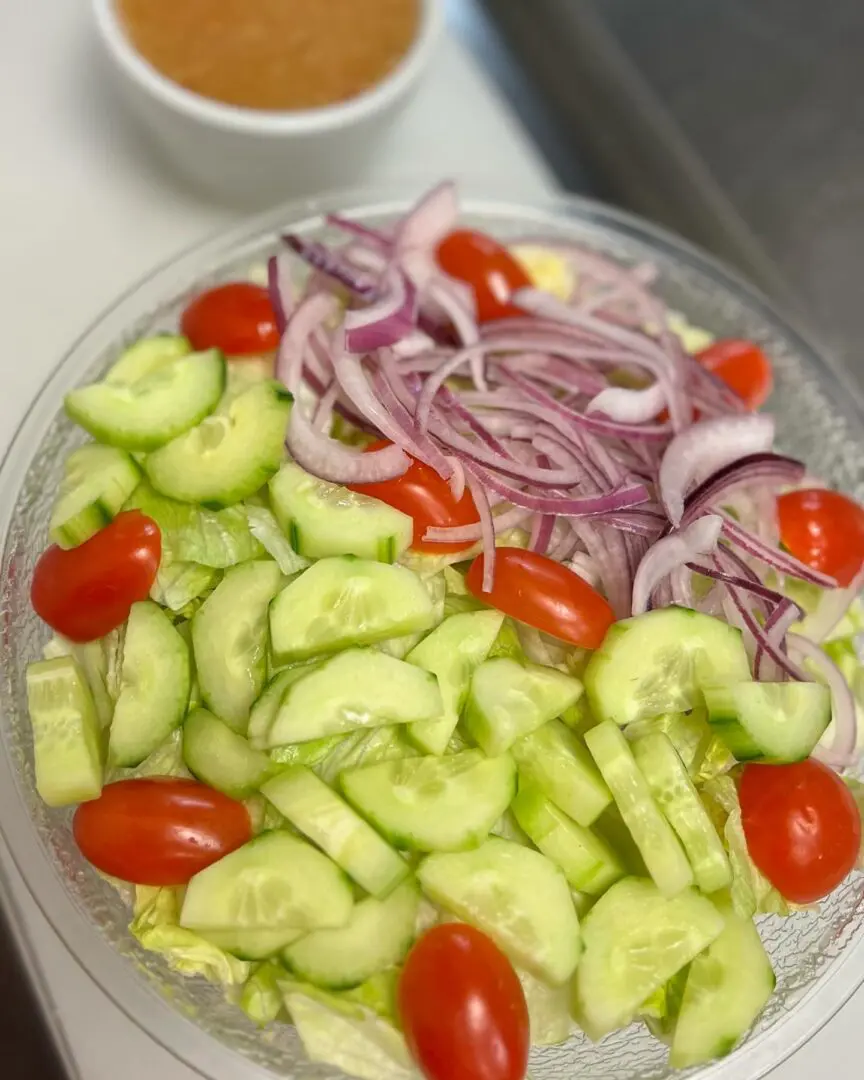 A bowl of salad with cucumbers and tomatoes.